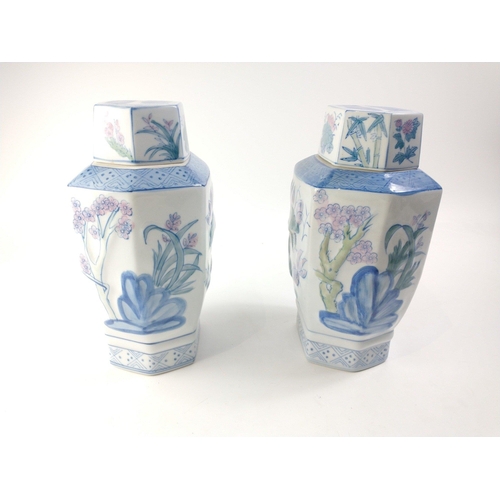 233 - Two Oriental lidded vases with 3D effect lotus and bamboo pattern.  Each stands 31cm tall inc. lids.... 