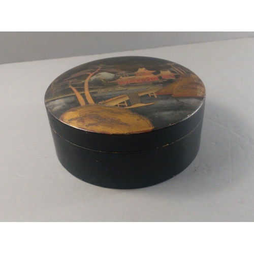 235 - A black lacquered round box with an Japanese design with Mount Fuji in the background, diameter 18cm... 