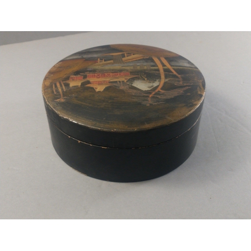 235 - A black lacquered round box with an Japanese design with Mount Fuji in the background, diameter 18cm... 