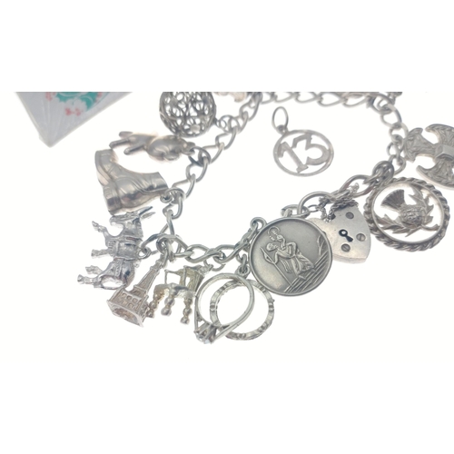 246 - A small sterling silver charm bracelet with some silver and white metal charms with some additional ... 