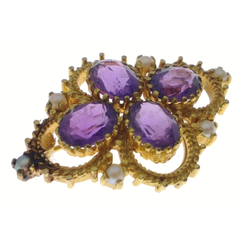 31 - A hallmarked gold brooch stamped 375, set with 4 amethysts and 6 seed pearls.  Brooch measures 40mm ... 