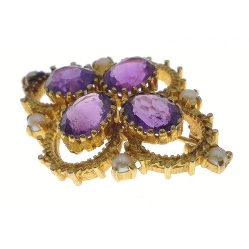 31 - A hallmarked gold brooch stamped 375, set with 4 amethysts and 6 seed pearls.  Brooch measures 40mm ... 