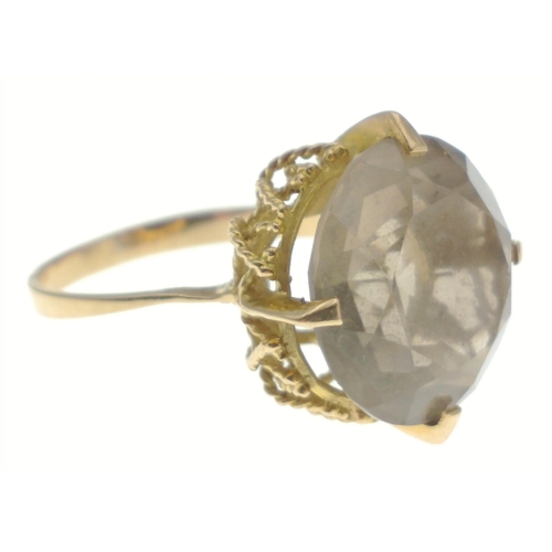 79 - An unmarked yellow metal ring with large quartz smoky stone measuring 12mm approx, size O, gross wei... 