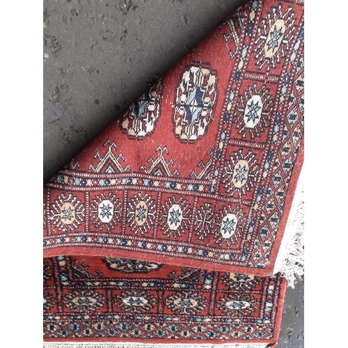 490A - A small fringed red rug with 6 centre medallions 95x66cm approx#118