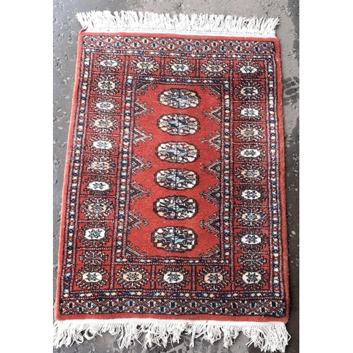 490A - A small fringed red rug with 6 centre medallions 95x66cm approx#118