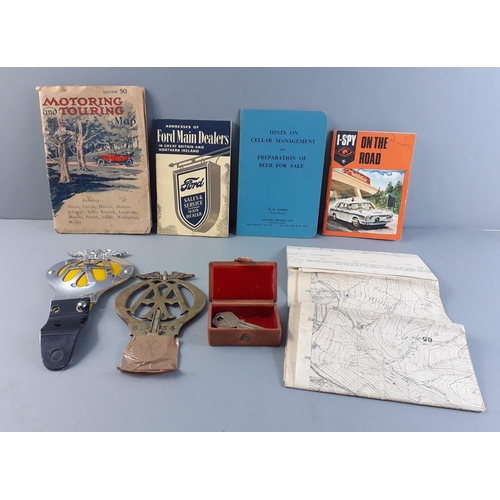 691 - A small selection of motoring and automotive ephemera to include a vintage numbered brass AA badge 6... 