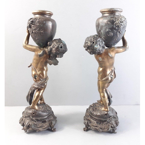 251 - After AUGUSTE MOREAU. A pair of spelter and metal figures depicting cherubs holding vases.  Damage t... 