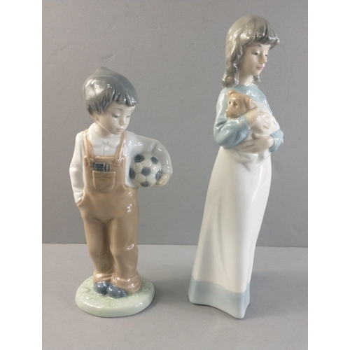 254 - Two NAO figures. One of a young boy with football and one of a young girl cradling a small dog in a ... 