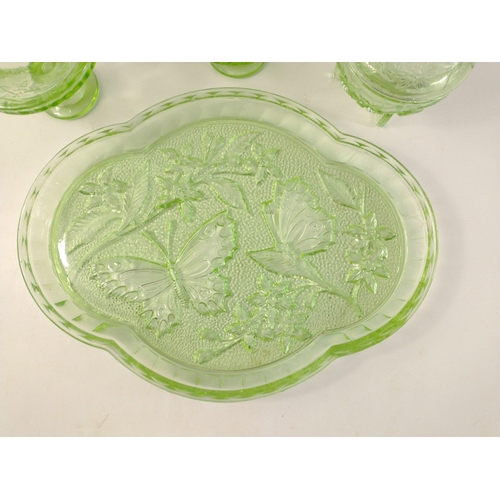 324 - Green glass dressing table set with floral and butterfly embossed design to include a tray (approx 3... 