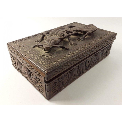 338 - An ANTIQUE Oriental carved wooden box with a fierce 3D dragon on the lid. The lid has become detache... 