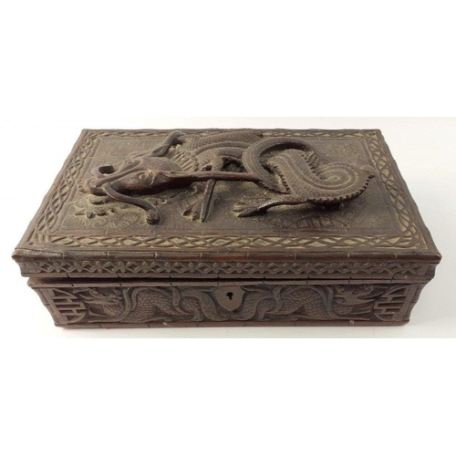 338 - An ANTIQUE Oriental carved wooden box with a fierce 3D dragon on the lid. The lid has become detache... 