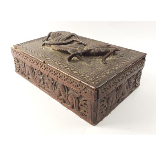 338 - An ANTIQUE Oriental carved wooden box with a fierce 3D dragon on the lid. The lid has become detache... 