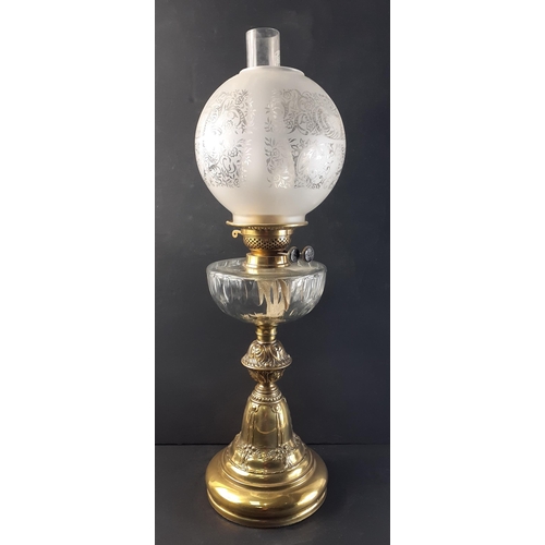 202 - Substantial embossed brass based oil lamp with chimney and globe shade. Burner dials marked with sai... 