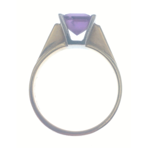 28 - A 375 hallmarked yellow gold ring set with amethyst flanked with white gold. Stone has a slight chip... 