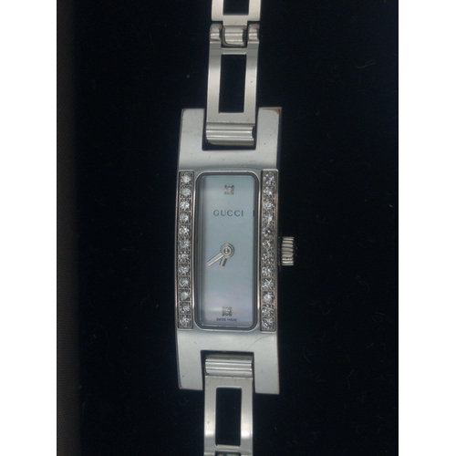 17 - An original GUCCI ladies cocktail watch. Mother of Pearl face with two inset diamonds and a further ... 