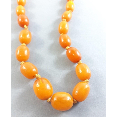 71 - A string of graduated butterscotch amber-style  beads 60cm long approx, weight 29g approx. Note one ... 