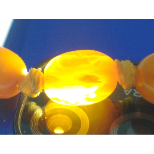 71 - A string of graduated butterscotch amber-style  beads 60cm long approx, weight 29g approx. Note one ... 