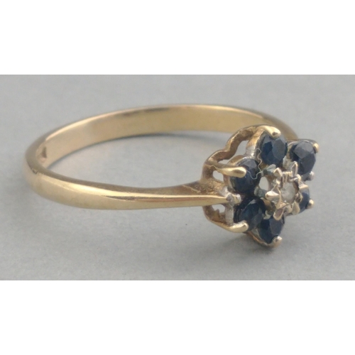 26 - A 375 hallmarked 9ct gold ring with small diamond centre stone and six sapphire surrounds. Size P Gr... 