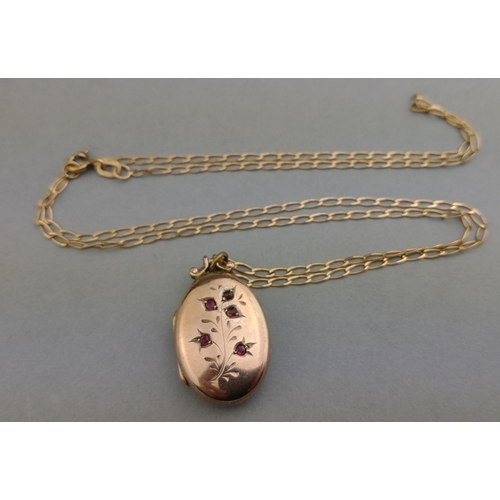 28 - A 375 stamped chain with an unmarked yellow metal pendant with small red stones as decoration - the ... 