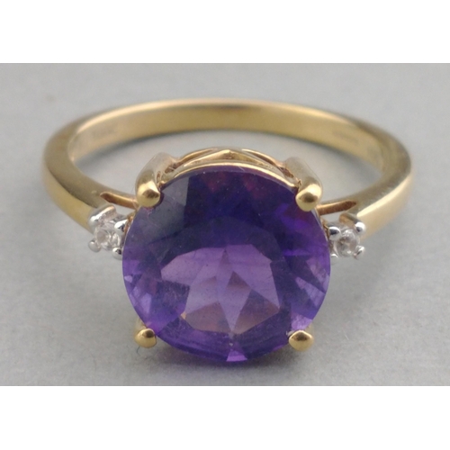 43 - A 10K stamped gold 375 hallmarked ring with 14mm amethyst centre stone and two small diamonds to sho... 