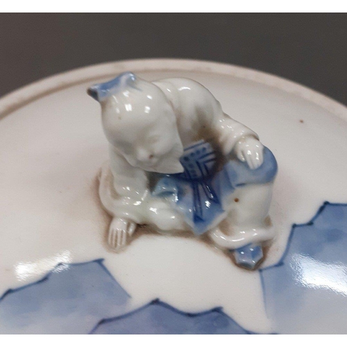 432 - A lovely blue and white Oriental jar with a figural finial of a sitting peasant. Stands 24cm approx ... 