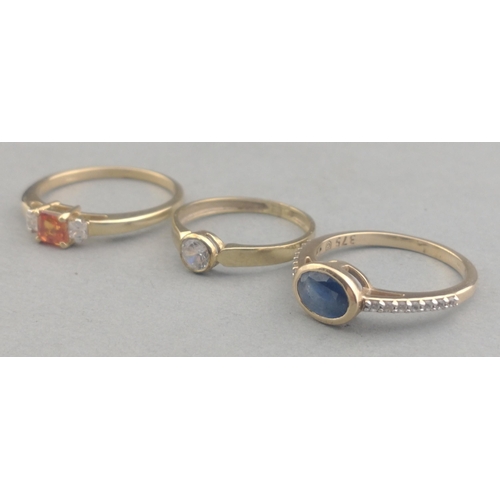 57 - Three 375 stamped rings one with an oval SAPPHIRE and one with a rectangular cut SPESSARTINE GARNET ... 