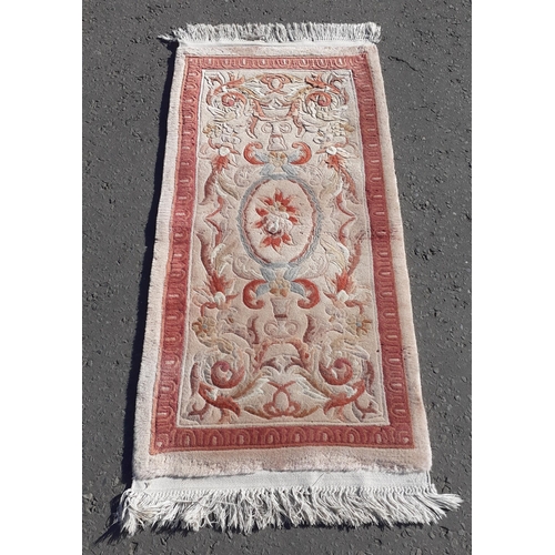 329 - A useful CHINESE wool rug with fringe and pink theme.  140 x 60cm approx.#38