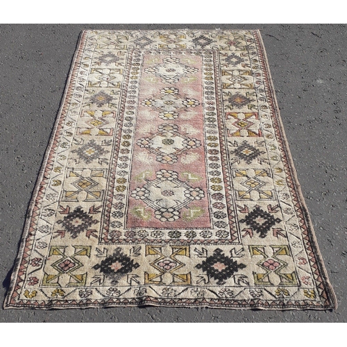 330 - A vintage rug with rectangular centre piece panel with four rosettes.  175cm x 110 cm approx.#39