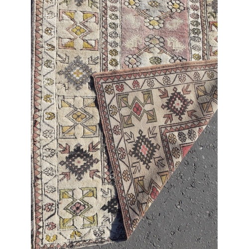 330 - A vintage rug with rectangular centre piece panel with four rosettes.  175cm x 110 cm approx.#39