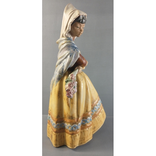 294 - A LLADRO figurine of a young girl holding a posy of flowers.  Stands 35cm tall with no damage.#345... 