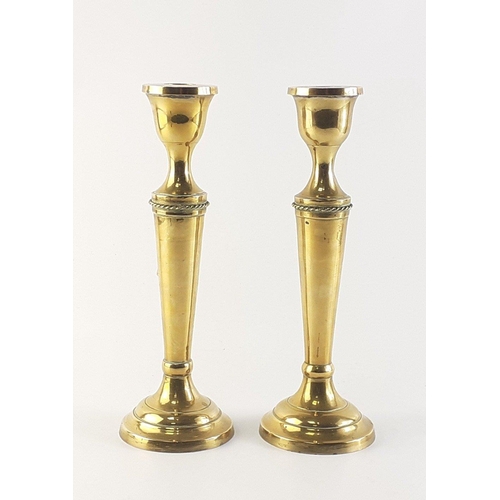 66 - A pair of very attractive brass candlesticks with tassel rope adornments. Each stands 25cm high. In ... 