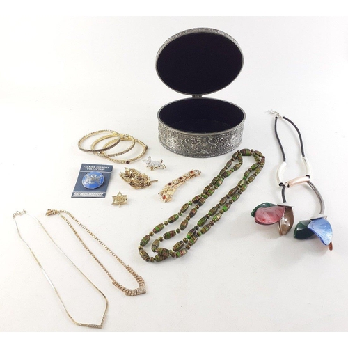 72 - A heavyweight oval metal jewellery box containing enamelled brooches, bangles etc#73