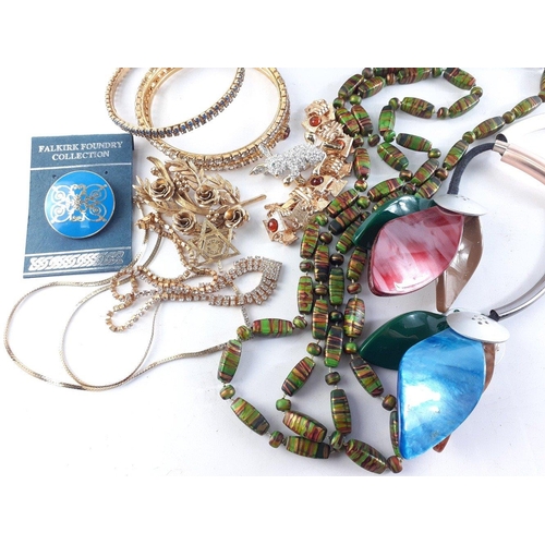 72 - A heavyweight oval metal jewellery box containing enamelled brooches, bangles etc#73