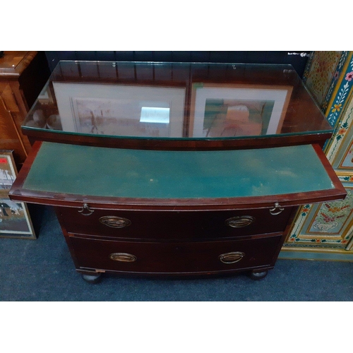 129 - A 19th century bow fronted mahogany three drawer chest of drawers with a concealed pull-out correspo... 