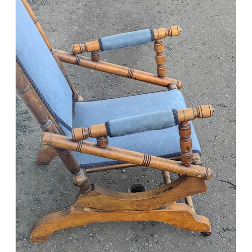 227 - A late Victorian beechwood American rocking chair with blue floral fabric covering. Height 103cm app... 
