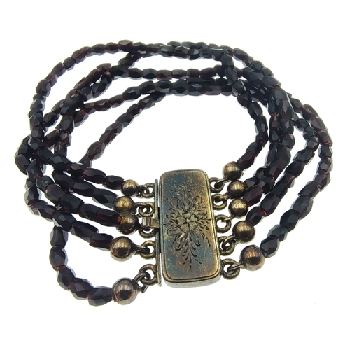 30E - An EXQUISITE VICTORIAN deep red garnet multi-strand bracelet on an unmarked white metal decorative f... 