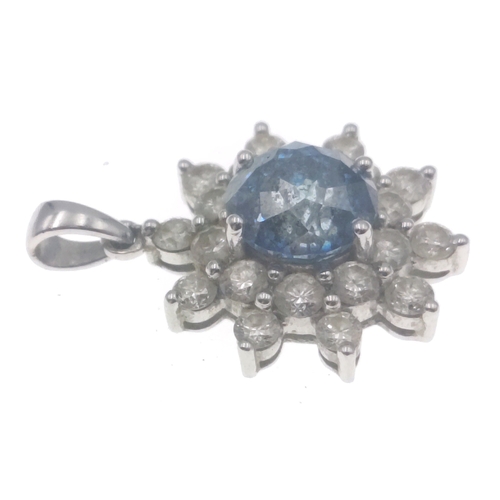 20 - A rare BLUE DIAMOND pendant set in a floral bed of twenty white diamonds set on a 14K white gold mou... 