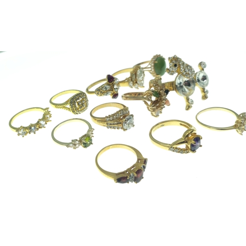 187 - A dozen BLING rings in bright gold style finishes. Assorted sizes and stones.