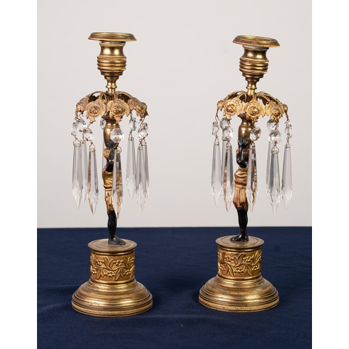 89 - PAIR OF REGENCY PATINATED AND GILT BRONZE FIGURAL CANDLESTICKS, each modelled a Blackamoor supportin... 