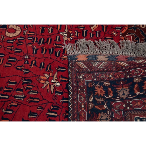 19 - AN ATTRACTIVE SEMI-ANTIQUE TURKISTANI WOOL PILE CARPET, overall predominately red and indigo, the fi... 