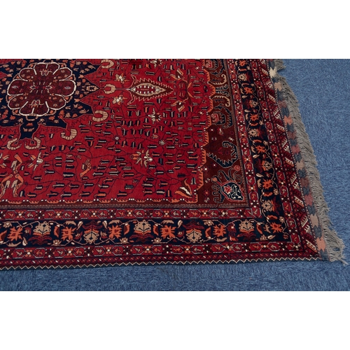 19 - AN ATTRACTIVE SEMI-ANTIQUE TURKISTANI WOOL PILE CARPET, overall predominately red and indigo, the fi... 