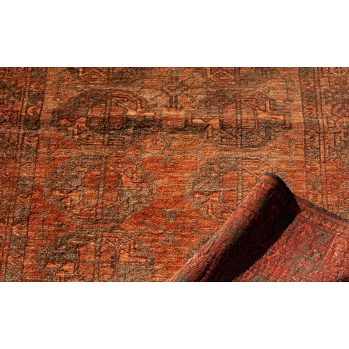 14 - TURKOMAN RUG IN SUBDUED BLACK AND RED COLOURS with two rows of seven large primary guls, the prinicp... 