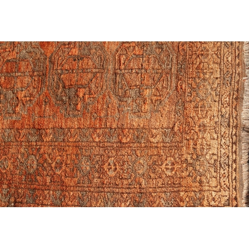 14 - TURKOMAN RUG IN SUBDUED BLACK AND RED COLOURS with two rows of seven large primary guls, the prinicp... 