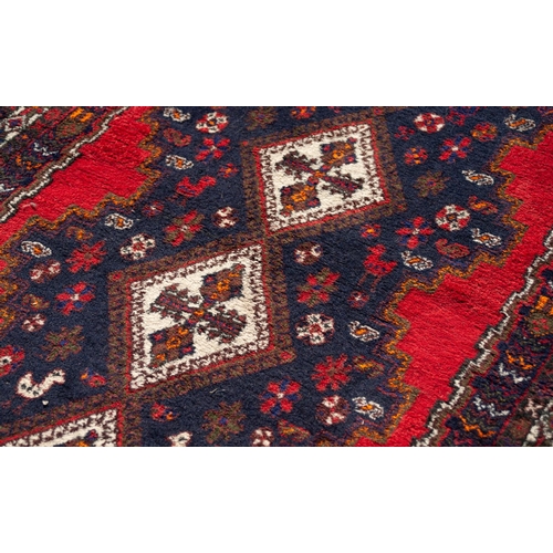 15 - LARGE SHIRAZ RUG WITH A CHAIN OF FOUR WHITE GROUND DIAMOND SHAPED CENTRE MEDALLIONS, on a black grou... 