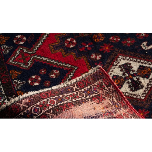 15 - LARGE SHIRAZ RUG WITH A CHAIN OF FOUR WHITE GROUND DIAMOND SHAPED CENTRE MEDALLIONS, on a black grou... 