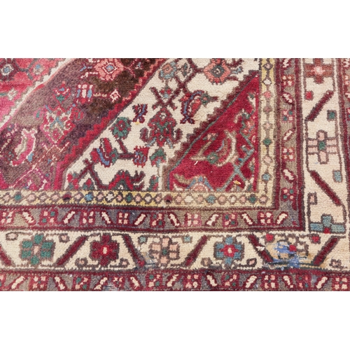 20 - EASTERN CARPET, with diamond shaped white medallion with pendants on a red and  herati  field  with ... 