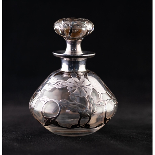 24 - AN EARLY 20TH CENTURY CLEAR GLASS WHITE METAL OVERLAID PERFUME BOTTLE WITH CONFORMING STOPPER