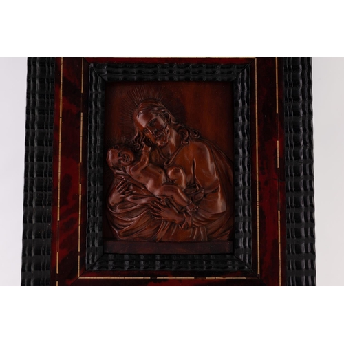 56 - AN 18TH CENTURY FLEMISH CARVED FRUITWOOD RELIEF OF JOSEPH CRADLING THE CHRIST CHILD, contained withi... 