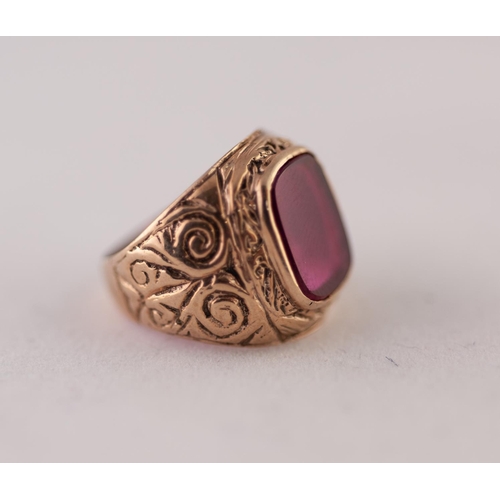 264Y - 9ct GOLD SYNTHETIC RUBY RING. A rectangular synthetic ruby plaque, in a rubbed over setting, to a sc... 