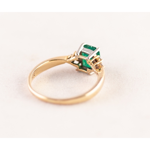 303 - A GOLD (no carat mark) RING, set with an emerald between shoulders set with six tiny diamonds, 4.1gm... 